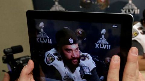 Un reportero utiliza un iPad  para grabar al jugador de los Ravens de Baltimore, Haloti Ngata.