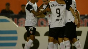 Brizuela (segundo izq.) es felicitado por Omar  y sus compañeros tras anotar el primer gol de Atlas.