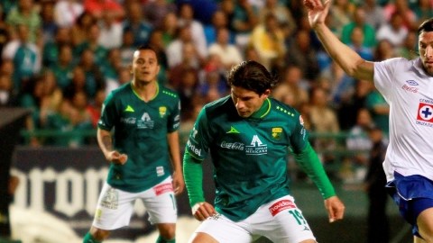 El argentino Mariano Pavone (der.), autor de dos goles para Cruz Azul, pierde el lance  ante Jonny Magallón (centro), de León.