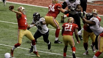El quarterback Colin Kaepernick (7) de los San Francisco 49ers lanza un pase mientras que el linebacker  de los Ravens de Baltimore, Dannell Ellerbe (59), corre durante la segunda mitad del Super Bowl jugado ayer en Nueva Orleáns. Fue un loco Super Bowl que tuvo hasta un insólito apagón que provocó una demora de 34 minutos.