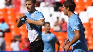 El uruguayo Nicolás López (izquierda) celebra después de anotar  un gol ante la selección   de Ecuador. Tras vencer 1-0 el cuadro charrúa  irá al  certamen orbital.
