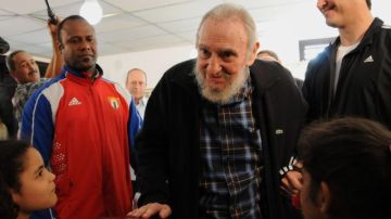 Fidel Castro es observado con admiración por menores durante su aparición para emitir su voto ayer.