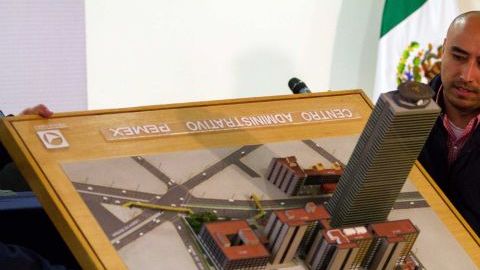 Una persona muestra la maqueta de la torre de PEMEX durante la rueda de prensa en Ciudad de México que ofreció el procurador general Jesús Murillo Karam.