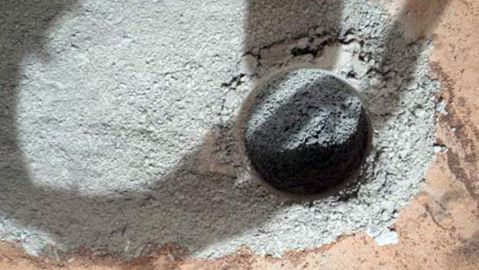 Foto proporcionada por la NASA, donde se ve al vehículo Curiosity perforando una roca marciana.