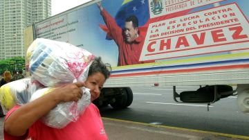 Una venezolana carga con bolsas con provisiones de alimentos.