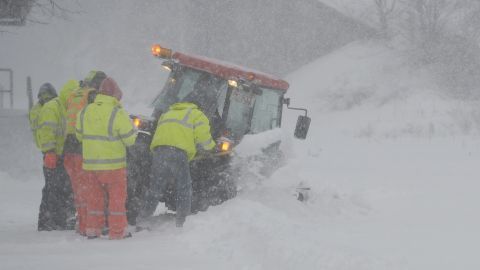 Brigadas empujan un tractor estancado en una carretera de Boston.