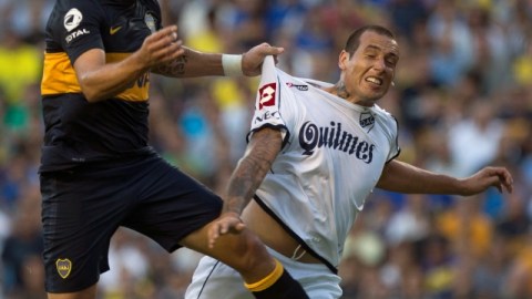 El delantero uruguayo Santiago Silva (izq.) de Boca Juniors, disputa el esférico con Wilfredo Olivera de Quilmes durante la primera jornada en Argentina.