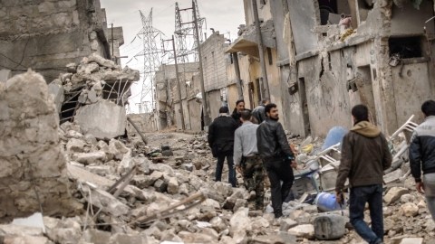 Varios rebeldes del Ejército Libre Sirio (FSA), caminan a través de las ruinas en el barrio de Sheik Saaid de Alepo,  donde se enfrentan a las tropas gubernamentales.