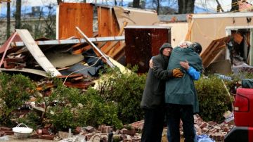 Los hermanos Michael y Colin Pierce reciben consuelo de su amiga Susan Hrostowski al ver los destrozos que causó el tornado en la casa de sus padres, en la localidad de Hattiesburg, Misisipi.