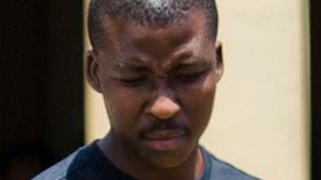 El atleta sudafricano Oscar Pistorius se cubrió hoy cuando agentes de la policía lo trasladaron de su casa a otro lugar.