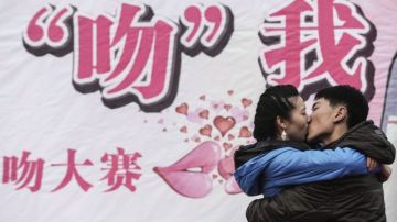 Una pareja  de chinos se besa sobre un escenario en el Centro Olímpico de Vela Qingdáo como parte del Concurso del Beso, celebrado hoy.