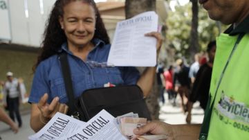 Una mujer vende en una calle de Caracas la Gaceta Oficial donde se ha publicado la devaluación del bolívar.