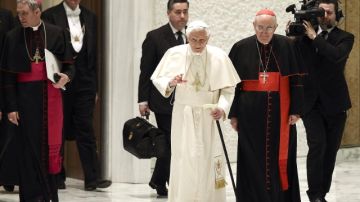 Benedicto XVI llega al Aula Pablo VI (c) apoyado en un bastón durante la reunión que celebró con los sacerdotes de la diócesis de Roma, en la Ciudad del Vaticano.