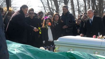 Steven Sierra arroja una flor sobre el ataúd que contiene los restos mortales de quien fuera su esposa por 15 años, Saraí Sierra.