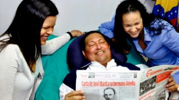 El presidente Hugo Chávez, acompañado de sus hijas María Gabriela, izq, y Rosa Virginia leyendo el diario Granma del jueves.