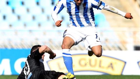 Carlos Vela evita la barrida de Iborra, del Levante, en el encuentro de ayer, por la jornada 26 de la Liga Española, en el Estadio Anoeta.