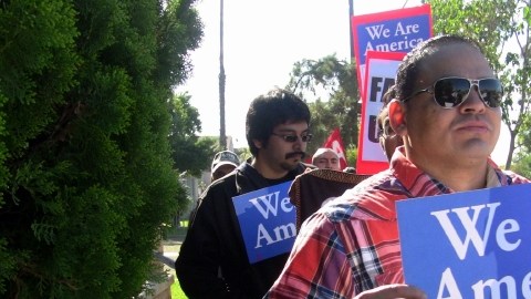 Inmigrantes  llevan carteles, durante una marcha  para exigir al presidente  Barack Obama, que decrete una moratoria en las deportaciones.