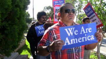 Inmigrantes  llevan carteles, durante una marcha  para exigir al presidente  Barack Obama, que decrete una moratoria en las deportaciones.