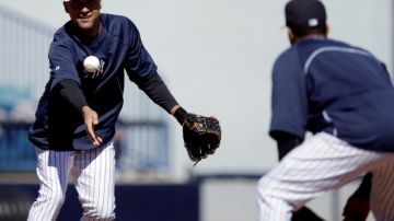 Derek Jeter, el capitán de los Yankees,  lanza una pelota a Robinson Canó durante una práctica el día de ayer.