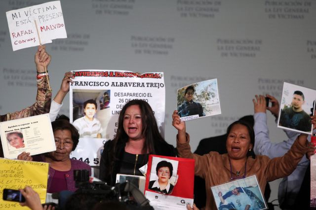 Familiares de víctimas de la violencia protestan durante la publicación de la Ley General de Víctimas, en Ciudad de México.