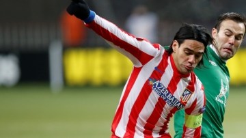 Radamel Falcao recorta a dos defensas del Rubin Kazan durante el duelo en que el Atlético de Madrid fue eliminado de la Liga Europa.