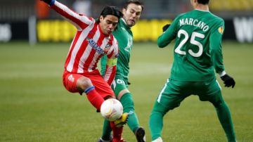 Radamel Falcao recorta a dos defensas del Rubin Kazan durante el duelo en que el Atlético de Madrid fue eliminado de la Liga Europa.