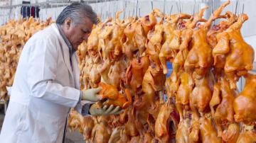El director del Rastro de Aves de la ciudad mexicana de León, Óscar Ramos Rodríguez, examina algunas aves sacrificadas para controlar la gripe aviar.