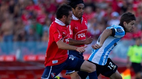 Luciano Vietto (12) escapa a la marca de  Federico Mancuello (izq.)  y Fabián Vargas, en el  derbi de Avellaneda que fue para los 'Rojos'.