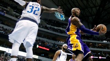 Kobe Bryant, de los Lakers, gira en el aire para depositar el balón en la canasta durante la victoria de su equipo 103-99 sobre los Mavericks de Dallas .