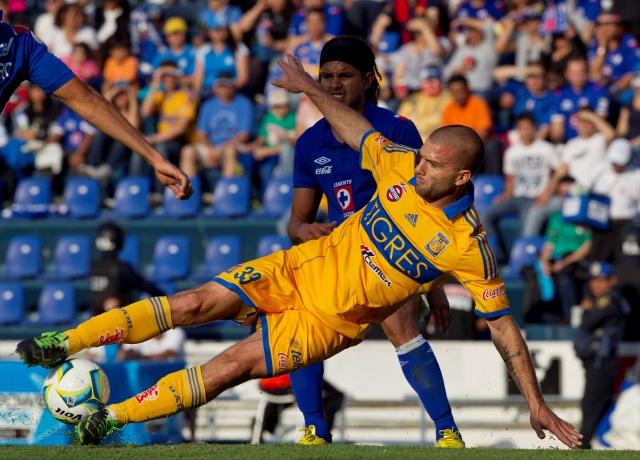 El argentino   Emanuel Villa (al frente) de Tigres, forcejea por el  control del esférico con  Gerardo Flores de  Cruz Azul.