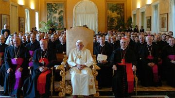 Foto de archivo publicada por el periódico 'El Observatorio Romano' muestra al papa Benedicto XVI (cen.) presidiendo una reunión con el secretario de Estado del Vaticano, el cardenal Angelo Sodano (izq.), en rojo.