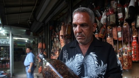 Mario, vendedor desde hace 30 años, muestra una botella de Mamajuana, en el Mercado Modelo, en Santo Domingo.