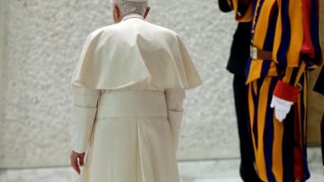 El papa Benedicto  XVI pasa junto a un guardia suizo al salir de la audiencia general en el Hall Pablo VI,  en el Vaticano el 13 de febrero de 2013.