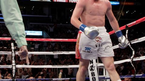 Saúl 'Canelo' Alvarez busca la esquina contraria luego de su impresionante victoria sobre el boxeador argentino Carlos Baldomir quien yace sobre el tapiz luego del violento nocaut propinado por el campeón mexicano de las 154 libras.