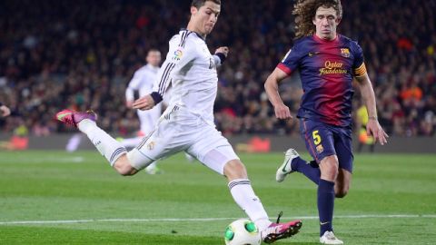El portugués Cristiano Ronaldo (izq.) del Real Madrid trata de anotar ante el asedio de Carles Puyol durante el juego de la Copa del Rey el martes pasado.