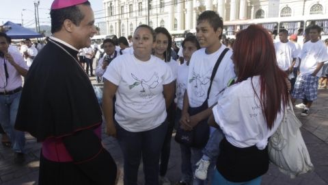 El obispo católico Fabio Colindres (i) conversa con expandilleros salvadoreños cuando asistían a un acto religioso