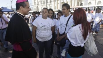 El obispo católico Fabio Colindres (i) conversa con expandilleros salvadoreños cuando asistían a un acto religioso