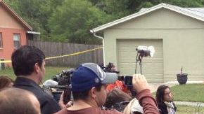 El jefe del departamento de Bomberos de Seffner, Florida, Ron Rogers (c-atrás), durante una rueda de prensa frente a la casa en la cual las autoridades tratan de rescatar a un hombre desaparecido en un socavón.