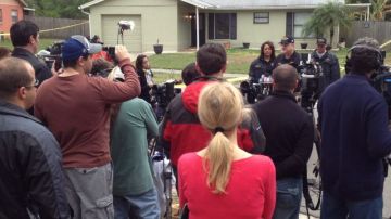 El jefe del departamento de Bomberos de Seffner, Florida, Ron Rogers (c-atrás), durante una rueda de prensa frente a la casa en la cual las autoridades tratan de rescatar a un hombre desaparecido en un socavón.