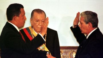 Hugo Chávez juramenta como presidente por primera vez en 1999, y toma el poder de manos de Rafael Caldera (centro), quien le dio un indulto presidencial.