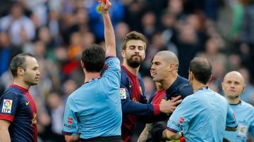 Gerard Piqué (con los ojos cerrados)  intentó calmar a Víctor Valdés, que gritaba con más coraje cuando el árbitro le sacó la tarjeta roja.