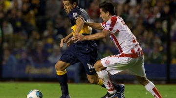 Juan Román Riquelme (izq.) es marcado por Diego Galvan de Unión, durante la derrota de Boca Juniors el   domingo por 3-1.