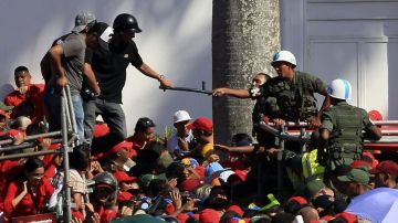 La policía y ejército venezolanos vigilan las filas de gente que espera hasta 12 horas para ver el cadáver de Chávez.