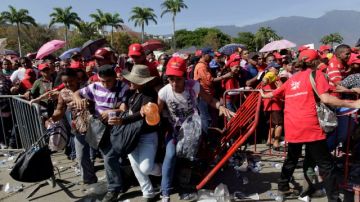 Los seguidores de Chávez rompen la barrera de la fila que lleva a ver los restos de Chávez.