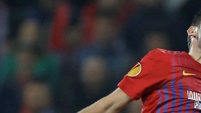 John Terry, del Chelsea, salta atrás del jugador del  Steaua de Bucarest,  Raul Rusescu,  en el juego de ayer celebrado en el National Arena.