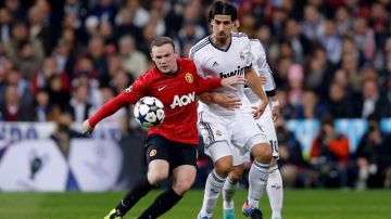 Wayne Rooney intenta controlar el balón ante la presencia de Sami Khedira, del Real Madrid en el cotejo que el cuadro merengue eliminó a los "Diablos Rojos".