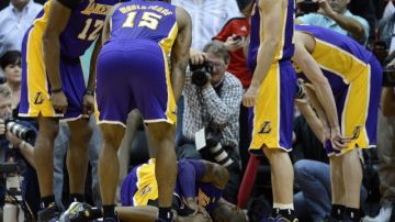 Kobe Bryant, de Lakers, se lamenta en la duela tras caer lesionado del tobillo izquierdo, el miércoles en el juego ante los Halcones de Atlanta, en el Phillips Arena.