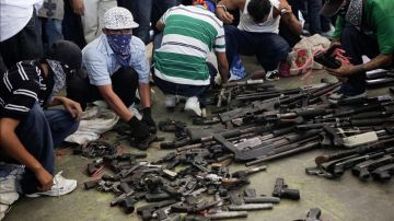 Pandilleros en la entrega de armas de fuego a las autoridades, en el municipio de Apopa, en El Salvador, que fue declarado como el sexto "municipio santuario".
