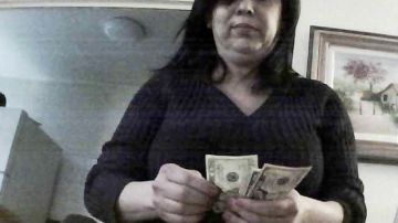 En la foto  aparece Adriana Ferreira contando el dinero recibido de una presunta víctima, que cooperó con la  fiscalía del condado  Suffolk para filmar a la mujer.