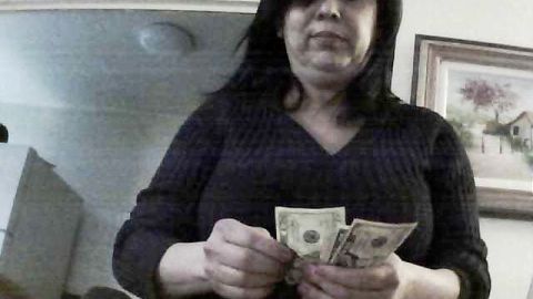 En la foto aparece Adriana Ferreira contando el dinero recibido de una presunta víctima, que cooperó con la fiscalía del condado Suffolk para filmar a la mujer.